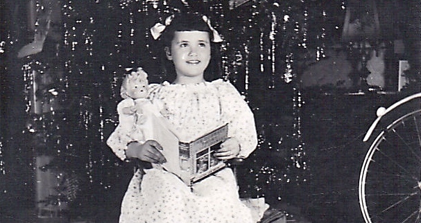 Girl holding songbook and doll